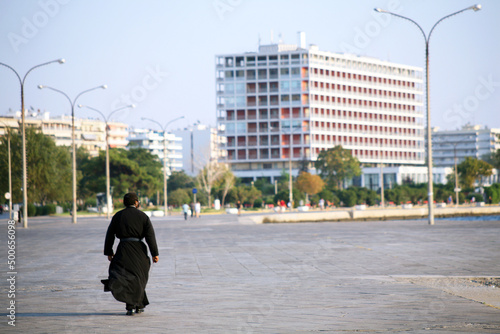 Priest walking at Thessaloniki seaside in Greece. Thessaloniki is the second largest city in Greece.