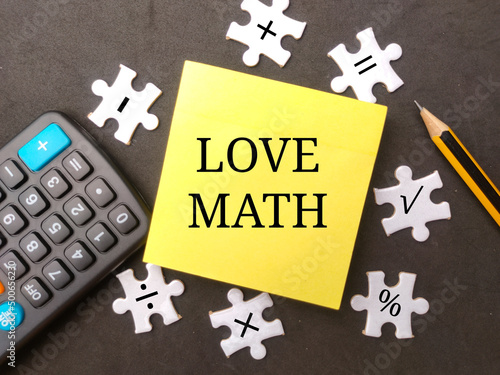 Education concept. Calculator,pencil and sticky note with the word LOVE MATH.
