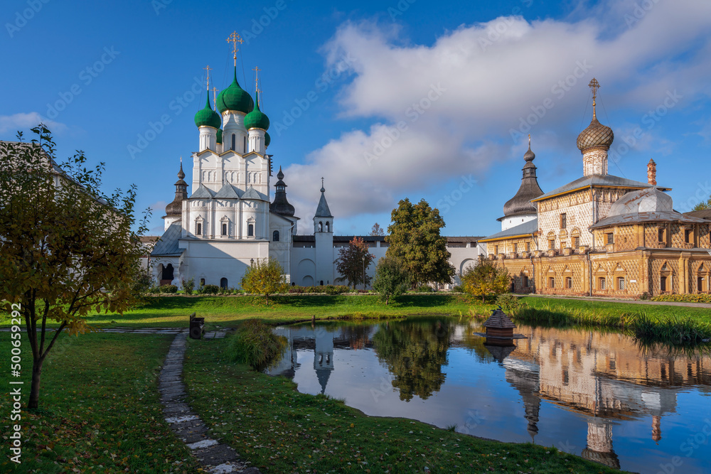 View of the Church of St. John the Theologian and the Church of the Hodegetria on the right against the background of the pond in Vladychy Dvor, Rostov Kremlin, Yaroslavl region, Russia