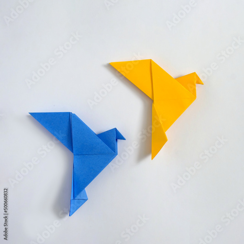 Japanese origami doves of peace yellow and blue concept of peace and help in the conflict in Ukraine and paper poster of hobby and entertainment.