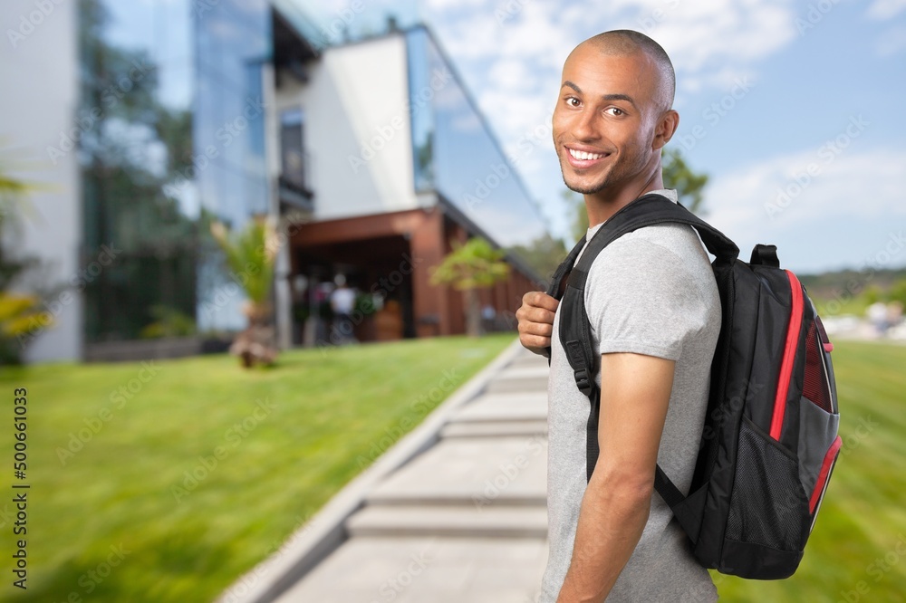 Naklejka premium Happy young student at the university background
