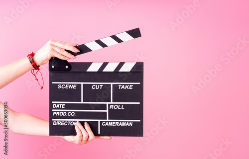 Canvas-taulu Female hands holding a clapper board isolated on pink