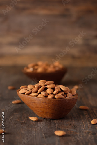 Almonds in wood bowl on wood table.Diet raw material