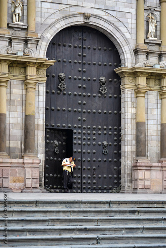 Security man standing at the door of an old church. © JuanSt