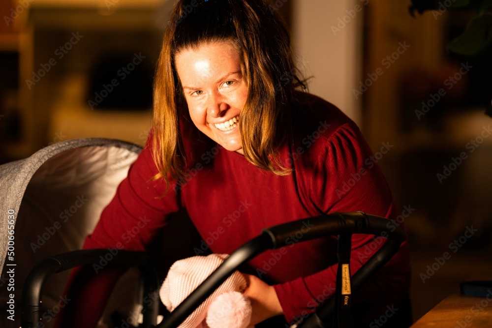 mother, woman, girl, looking after a baby in a pram, and pushing it, at night in a house and home on a cold night in melbourne, Australia. mother, woman, girl, looking after a baby in a pram, and pushing it, at night in a house and home on a cold night in melbourne, Australia.