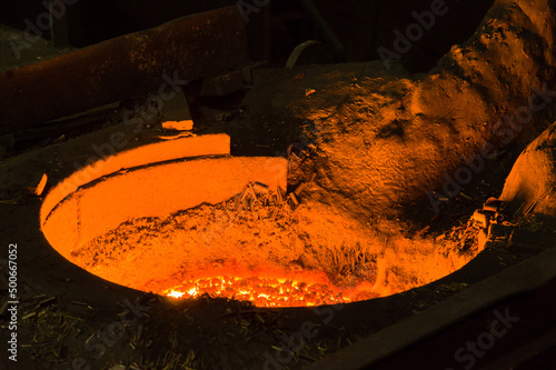 Closeup of glowing hot liqud metal in furnace photo