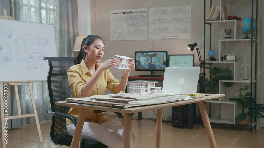 Asian Woman Engineer With A Laptop Making Paper Model Of House At The Office
Asian Woman Engineer With A Laptop Making Paper Model Of House At The Office