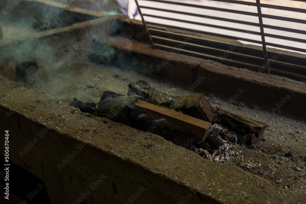firewood into bbq grill. Camping, cooking outdoors firewood into bbq grill. Camping, cooking outdoors