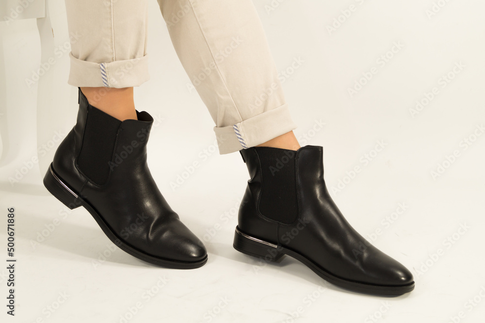 Close up view of a women's black leather chelsea boots. With white background. Footwear fashion concept.