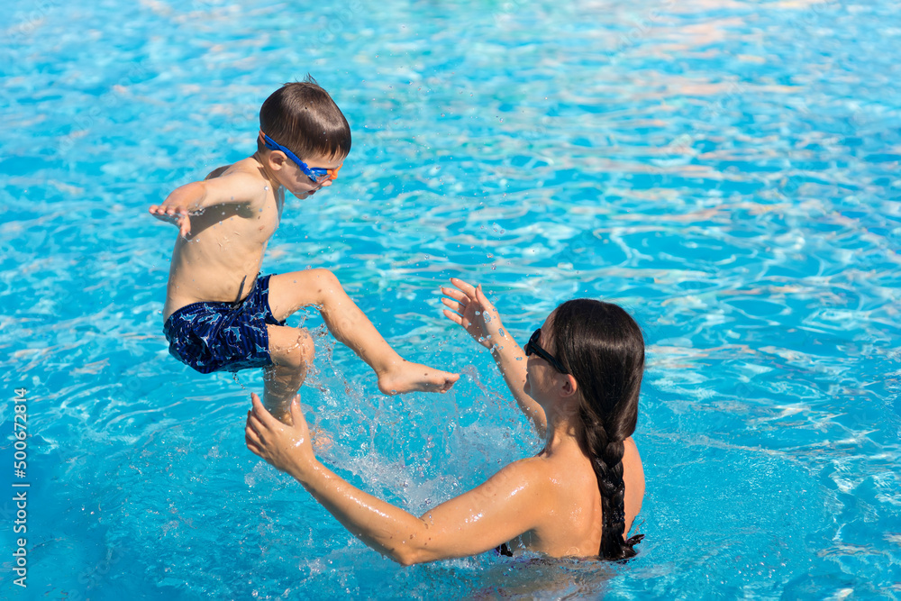 happy mother and son having fun in pool