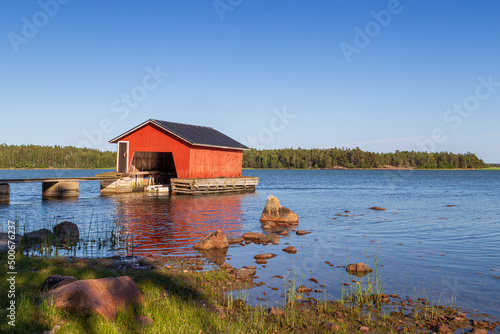 Wooden boathouse, shoreline and ocean in Åland Islands, Finland, on a sunny day in the summer Fototapet