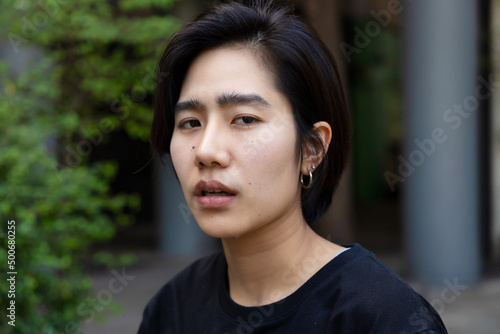 Sad and unhappy asian non-binary LGBT person crying