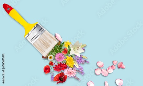 Spring or summer concept. Flowers and paint brush on pastel background. Flowers composition.