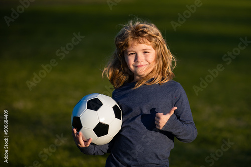 Boy child playing football on football field. Kid playing soccer show thumbs up success sign . Training for sport children. © Volodymyr