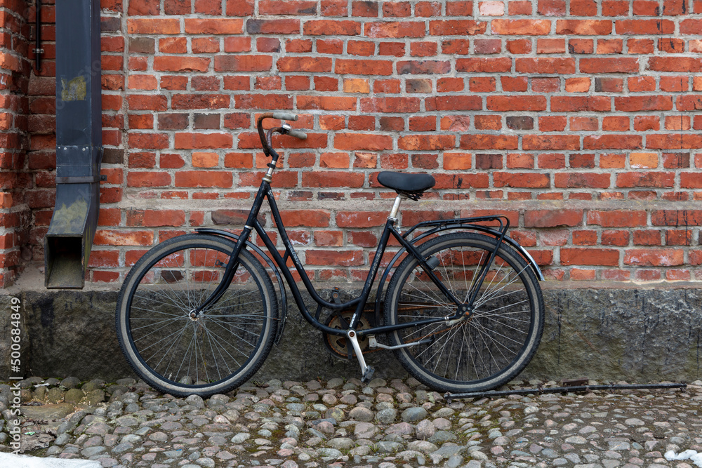 old bicycle in front of brick wall