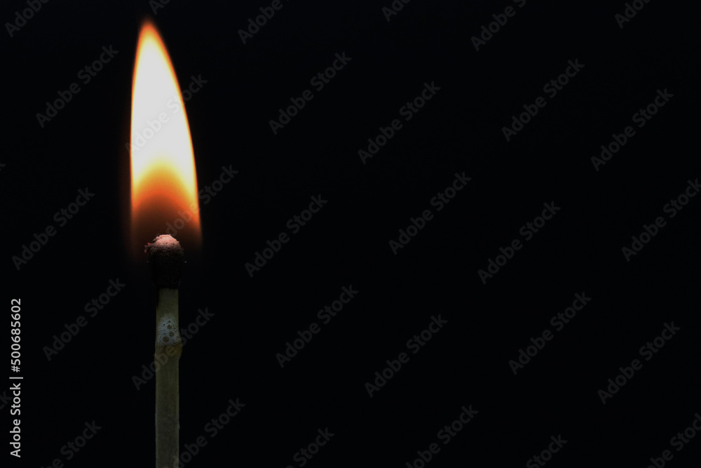 Burning match on black background for copy space Burning match on black background for copy space
