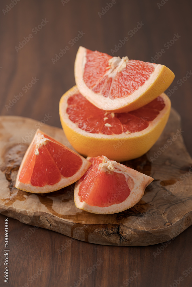 Sliced grapefruit on wood board closeup Sliced grapefruit on wood board closeup