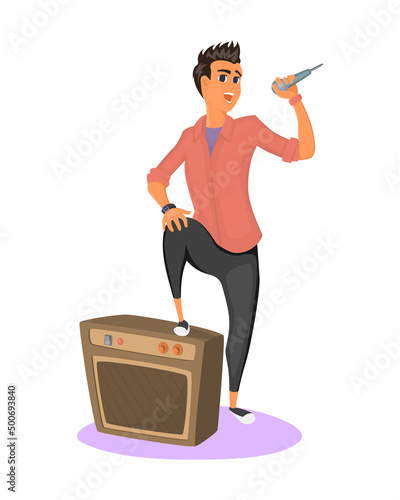Stylish teenager holds microphone in his hand and performs song. Young man stands with one foot on amplifier