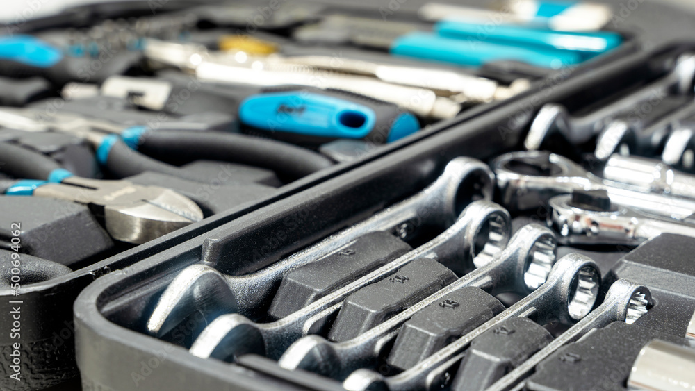 Fototapeta premium Close-up of a box with tools lies on the wooden floor against the backdrop of a motorcycle