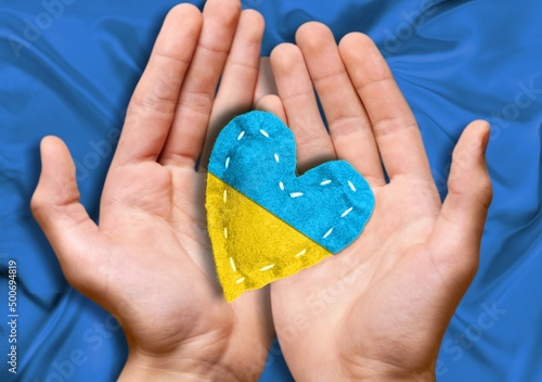 Hand with heart in colors of Ukrainian flag. Stop war in Ukraine concept .