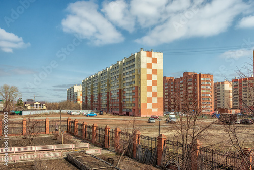 Urban landscape, multi-storey residential buildings against the background of a cloudy sky.