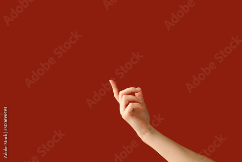 Hand of a woman holding a index finger up. Advertising concept for product. Empty place for product, logo, copy space
