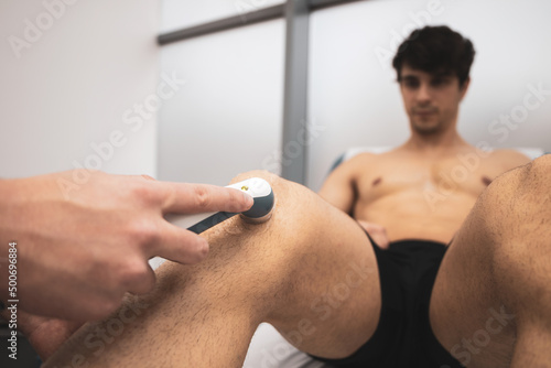 an Osteopath giving ultrasound treatment to a male client on the knee.