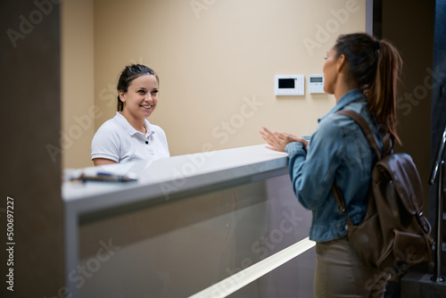 Happy receptions talks to a woman who is checking in at physical therapy center.