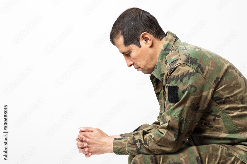 Shot of a soldier sitting on a bench and sadness with white background