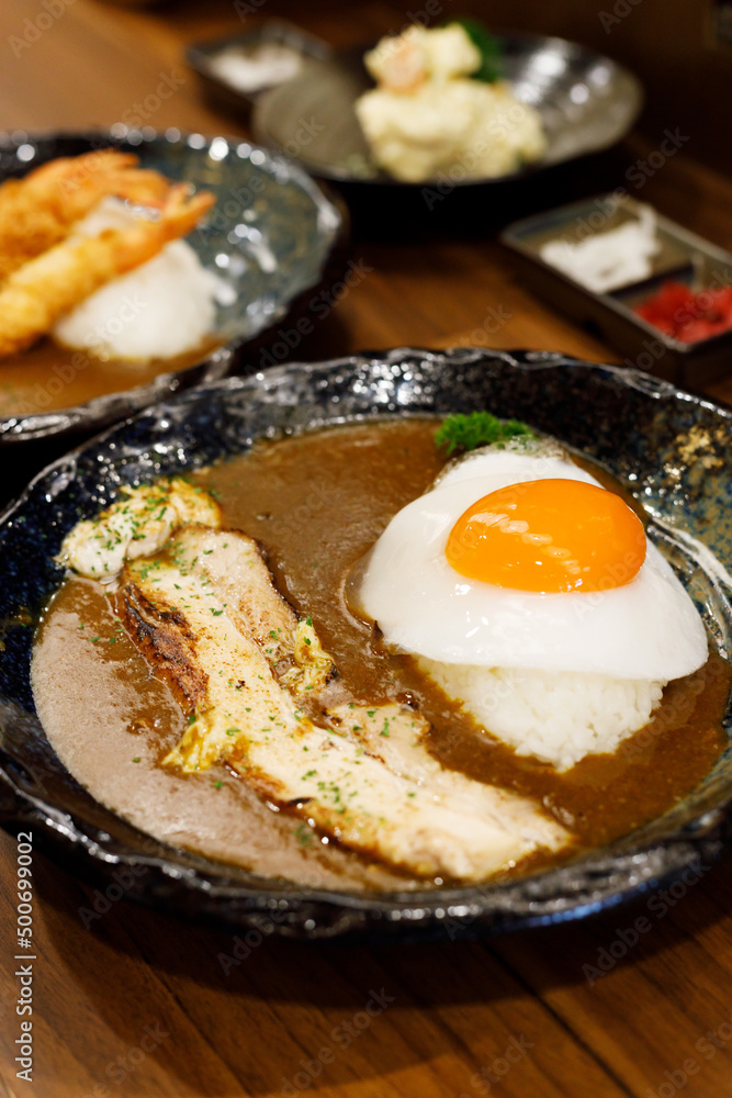 Japanese curry rice with fried egg and grilled pork belly. Japanese curry rice with fried egg and grilled pork belly.