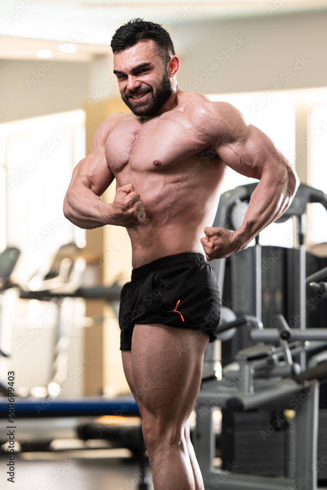 Handsome Muscular Man Flexing Muscles In Gym Handsome Muscular Man Flexing Muscles In Gym