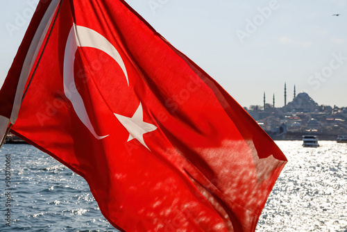 Waving Turkey flag and Istanbul view from water - travel background.