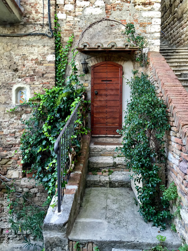 Viale Indipendenza Street view of Perugia  Umbria  Italy. Medieval stone house with ivy. Italian house. Fragment of facade. Wooden door. Stone wall  medieval building. Photo made in Umbria. 
