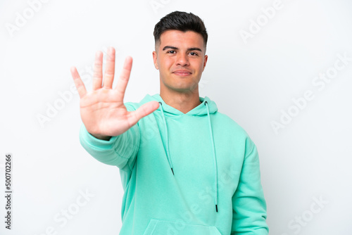 Young caucasian handsome man isolated on white background counting five with fingers © luismolinero