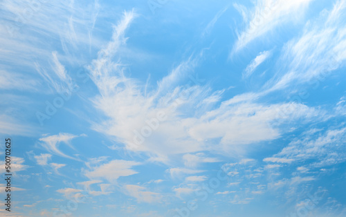 Blue sky and white clouds background - Pillowy clouds cover a blue sky in the background