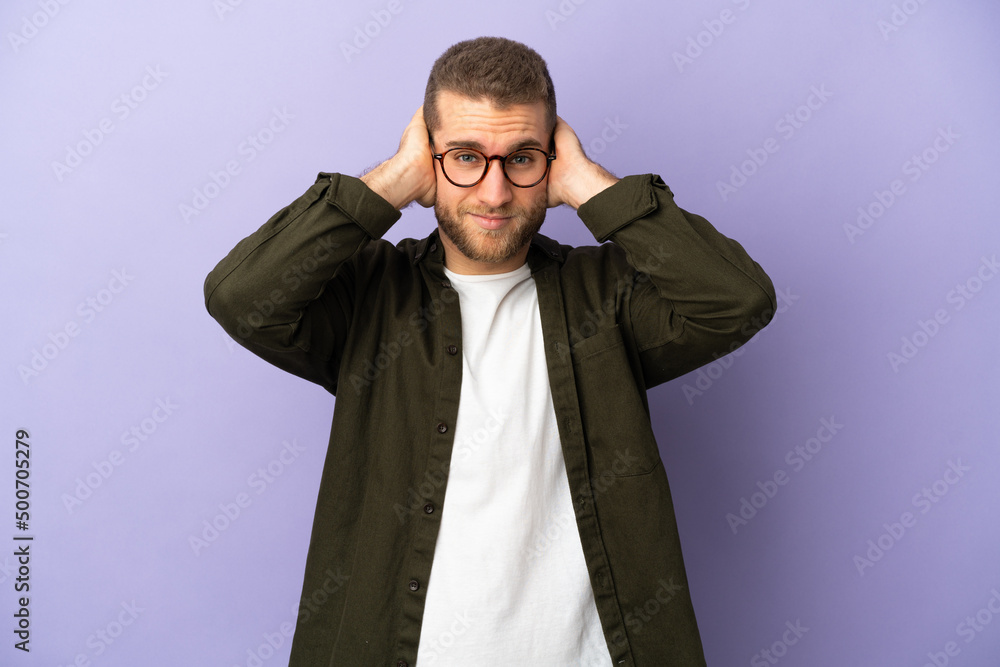 Young handsome caucasian man isolated on purple background frustrated and covering ears Young handsome caucasian man isolated on purple background frustrated and covering ears