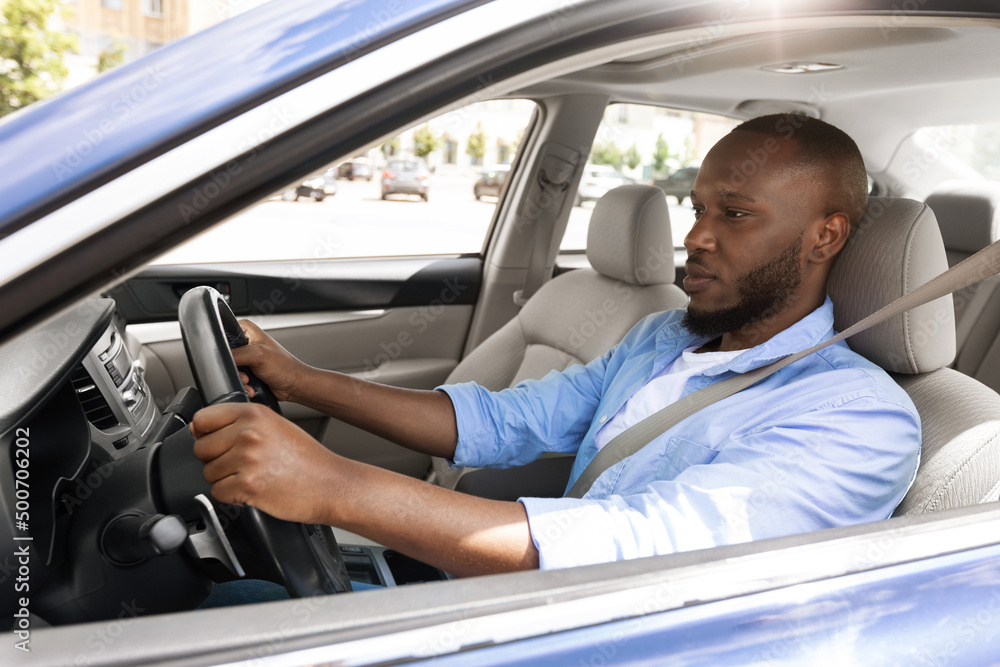 Confident black man driving new car in city Confident black man driving new car in city