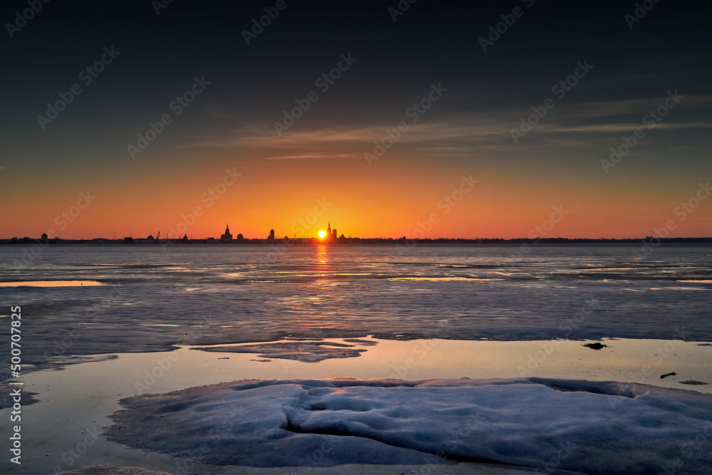 Silhouette of hanseatic city Stralsund with ice in foreground seen from Altefaehr in winter