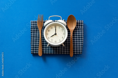 Food clock spoon and fork, Healthy food breakfast concept on blue table background