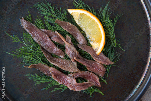 plate of anchovies with dill and lemon
