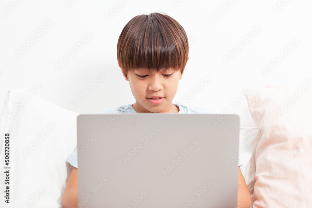 Cute asian boy using laptop at home during Covid-19 . Learning concept.Online education Cute asian boy using laptop at home during Covid-19 . Learning concept.Online education