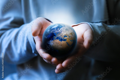 Close up child hands holding planet Earth. Earth day. Energy saving concept. World in business man hand on dark background. Save Earth. Environment Concept. 
Care of the Enviro.

