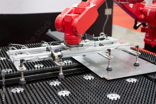 Fotografi Robot arm loading metal sheet to laser cutting machine in production line