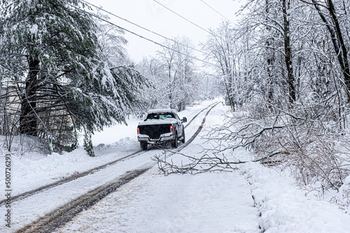 A late Spring Snow blankets Windsor, in Upstate NY, with up to 12 inches of wet snow in late April.  This snowstorm caused power outages for up to 4 days.  Truck drives around fallen branches. photo