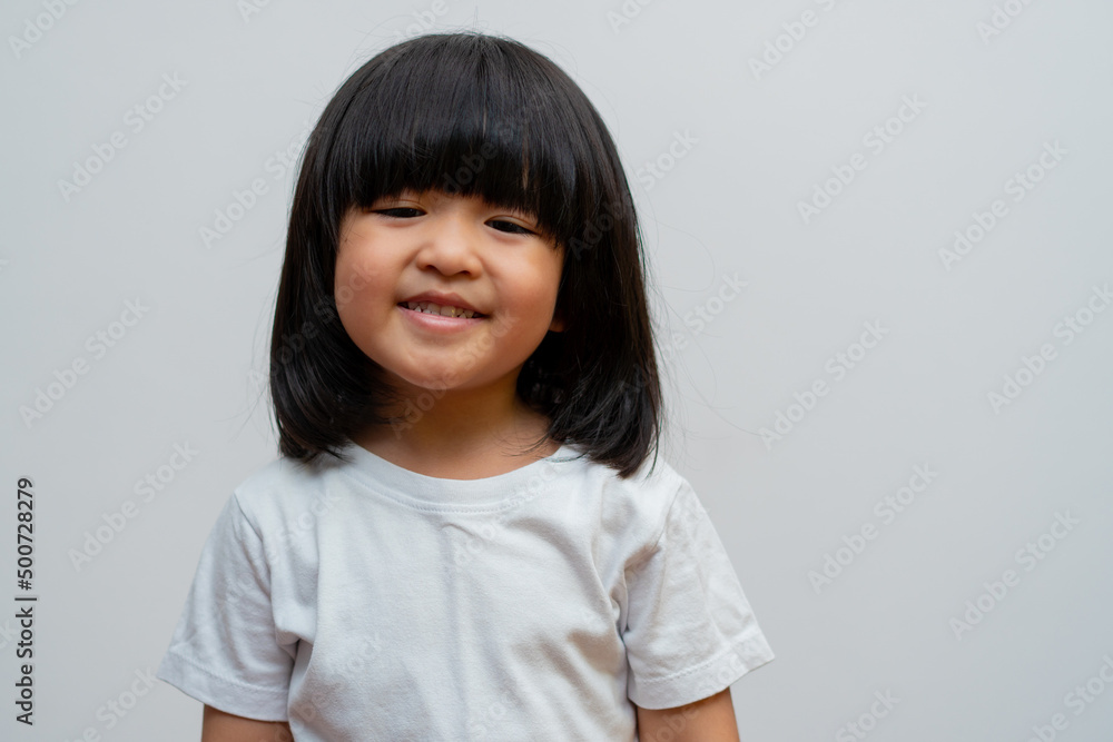 Portrait of happy and funny Asian child girl on white background, a child looking at camera. Preschool kid dreaming fill with energy feeling healthy and good concept Portrait of happy and funny Asian child girl on white background, a child looking at camera. Preschool kid dreaming fill with energy feeling healthy and good concept