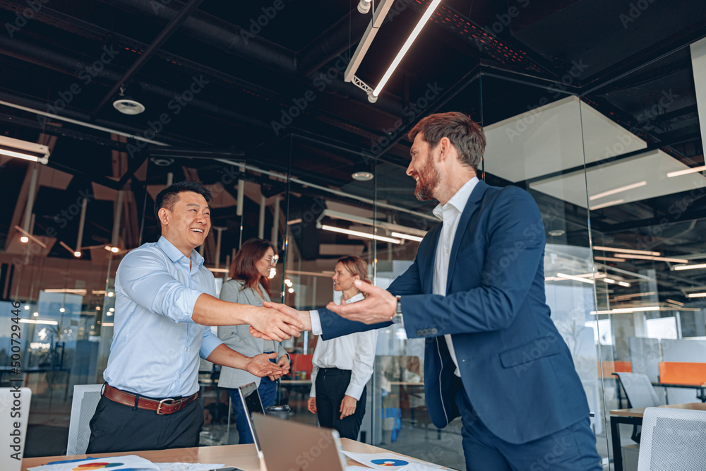colleagues are shaking their hands in modern office during teamwork. High quality photo colleagues are shaking their hands in modern office during teamwork. High quality photo