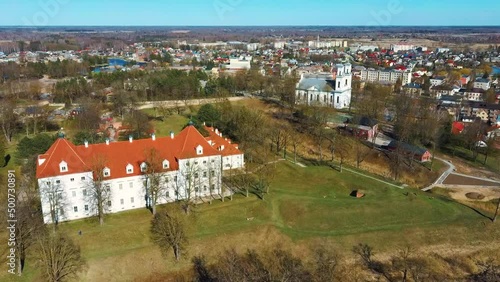 Aerial Shot of Birzai Castle, Fortress Birzai - a Castle in Birzai, on the Southern Coast of the Lake Širvėna in Lithuania, Sunny Spring Day. Historic Beautiful Church and Birzai City Panorama 4K UHD  photo