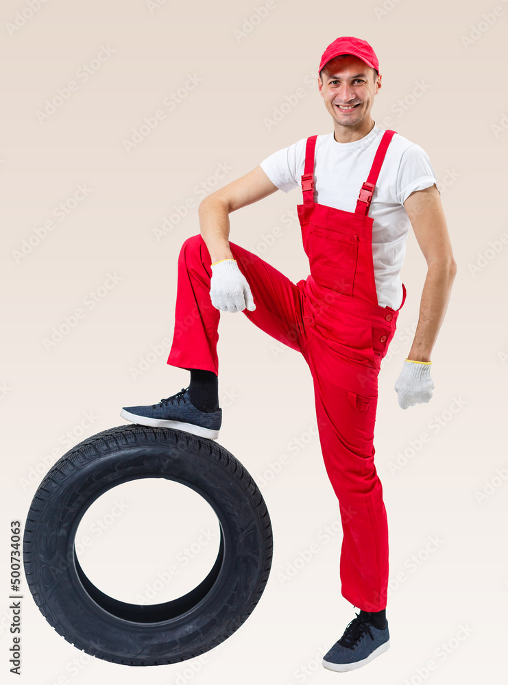working man in full growth holds a tire on a white background working man in full growth holds a tire on a white background
