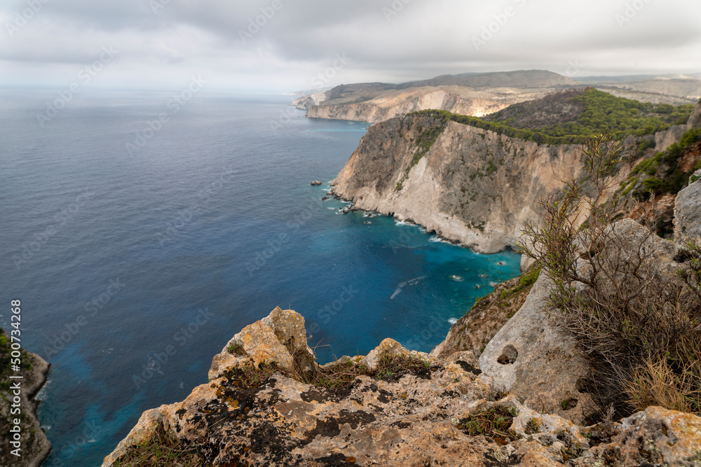 Obraz premium Famous cliff rock, sea, celar blue water, nature in Zakynthos Ionian island, Greece. Amazing view with multicolored clouds, clear sky. Island of lovers. Doors to heaven.