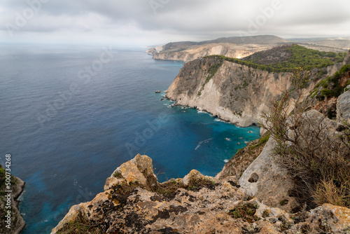 Famous cliff rock, sea, celar blue water, nature in Zakynthos Ionian island, Greece. Amazing view with multicolored clouds, clear sky. Island of lovers. Doors to heaven.